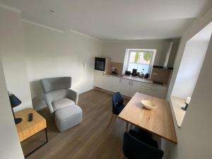 a living room with a table and a chair at Apartments Mühl17 in Münchweiler an der Alsenz