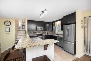 eine Küche mit schwarzen Schränken und einer Granitarbeitsplatte in der Unterkunft Beautiful wooded home in Popular SouthPark in Charlotte