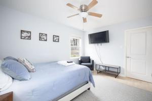 ein weißes Schlafzimmer mit einem Bett und einem Deckenventilator in der Unterkunft Beautiful wooded home in Popular SouthPark in Charlotte