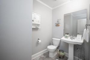 ein weißes Badezimmer mit Toilette und Waschbecken in der Unterkunft Beautiful wooded home in Popular SouthPark in Charlotte + 17 Fotos