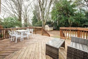 eine Holzterrasse mit einem Tisch und Stühlen darauf in der Unterkunft Beautiful wooded home in Popular SouthPark in Charlotte
