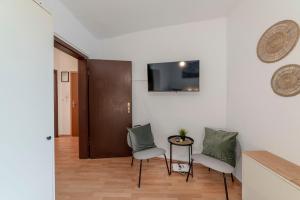 ein Wohnzimmer mit zwei Stühlen und einem Tisch in der Unterkunft Eco Retreat Spacestays - Smart TV - WIFI in Essen + 11 Fotos