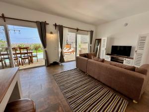 un soggiorno con divano e TV a schermo piatto di Beachfront Alma Villa with Private Pool ZanzibarHouses a Kiwengwa