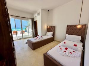 una camera con due letti e un balcone con vista sull'oceano di Beachfront Alma Villa with Private Pool ZanzibarHouses a Kiwengwa Altre 48 foto