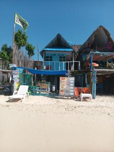 a building on the beach with two chairs on the sand at Cabaña Luna Azul in Playa Blanca