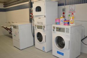 a laundry room with three washing machines and a sink at The Factory Residence Hall in Segovia
