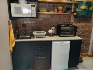 a kitchen counter with a sink and a microwave at Serenity 465 in De Kelders