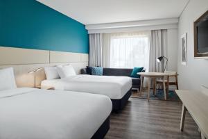 a hotel room with two beds and a table at Crowne Plaza Sydney Macquarie Park by IHG in Sydney