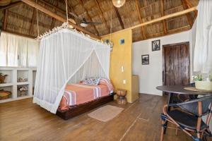 een slaapkamer met een bed met een klamboe bij Panchos Paradise Cabaña Parota in Puerto Vallarta