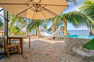 een tafel met een paraplu en een hangmat en de oceaan bij Panchos Paradise Cabaña Parota in Puerto Vallarta