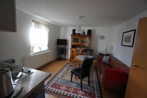 una sala de estar con un sofá y una mesa en Ferienwohnung am Olbersdorfer See, en Olbersdorf