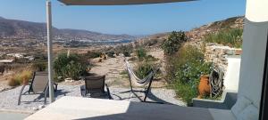 a patio with chairs and a hammock overlooking a valley at Sweet Home Nikorenia 2 in Krotiri