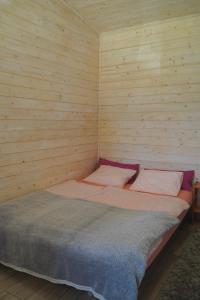a bedroom with a bed in a wooden wall at Domki nad jeziorem Węgorzyno in Augustowo