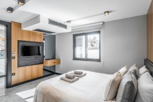 a bedroom with a large bed with a tv on the wall at Çimentepe Residence Deluxe 2 - Villa with Jacuzzi in Yalikavak in Bodrum City