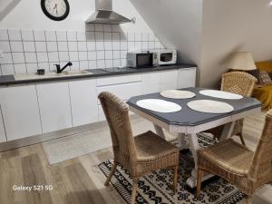 a kitchen with a table and chairs in a kitchen at La bruyère in Minihy-Tréguier