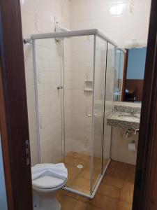 a bathroom with a glass shower with a toilet at Hotel Giordano Centro in São João da Boa Vista +29 photos