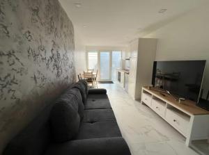 a living room with a couch and a television at IL punto in Avranches