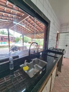 a kitchen counter with a sink and a window at Chácara Vista para Represa in Mogi das Cruzes