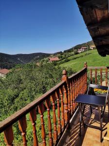 a balcony with a table and a view of a hill at Habitaciones con encanto en Ilurdoz in Zuriáin