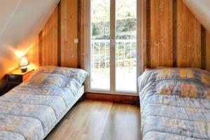 two beds in a room with a window at Villa ravissante à Loubressac avec piscine privée in Loubressac +12 photos
