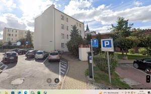 a parking lot with cars parked in front of a building at Apartament Olesno Centrum in Olesno