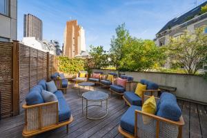 a rooftop patio with chairs and tables on a building at voco Paris Montparnasse by IHG in Paris