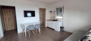 a kitchen with a table and chairs in a room at Apartmani Seaview in Sutomore