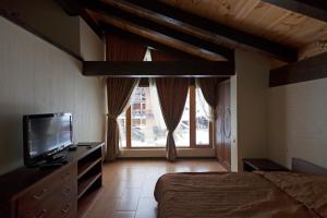 エストサドクにあるCottages Homutovskiy Dvorikのベッドルーム(ベッド1台、テレビ、窓付)