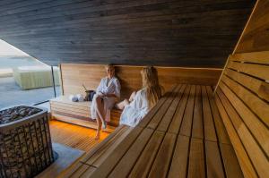 un hombre y una mujer sentados en una sauna en Panorama Hotell & Resort en Steinsland