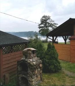 einen Steinkamin im Hof eines Hauses in der Unterkunft Domek nad jeziorem Węgorzyno in Augustowo