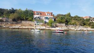 a group of boats in the water near a house at Spansa in Drvenik Veli