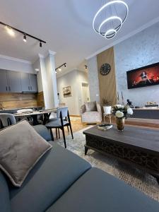 een woonkamer met een bank en een eetkamer bij Dior Apartment in Fier