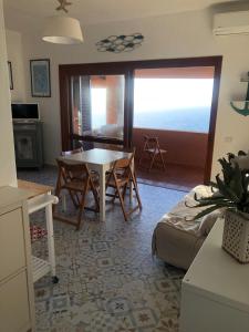 Una sala de estar con una mesa y sillas en una habitación. en The Belvedere di Achille, en Costa Paradiso