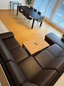 a living room with a couch and a table and chairs at LakeSide Villa - 18 in Niederried