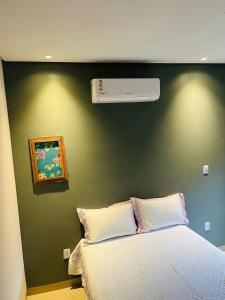 ManhãにあるRecanto dos Ipêsの緑の壁のベッドルーム(ベッド付)