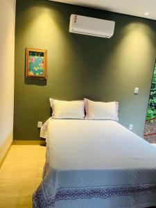 ManhãにあるRecanto dos Ipêsの緑の壁のベッドルーム1室(白いベッド1台付)