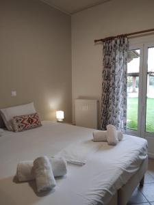 a bedroom with a large white bed and a window at Secret Garden in Diakopto