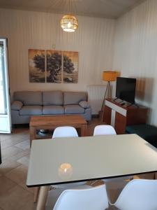 a living room with a couch and a table and chairs at Secret Garden in Diakopto