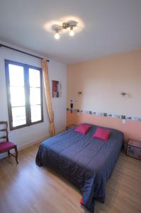 a bedroom with a blue bed and a large window at H&ocirc;tel du Commerce in Millau