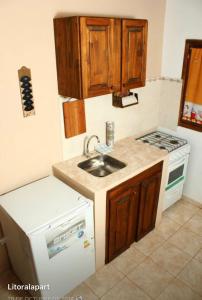 a kitchen with a sink and a stove at Litoral Apart in Eldorado