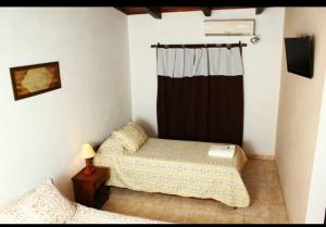 a bedroom with two beds and a curtain in it at Litoral Apart in Eldorado