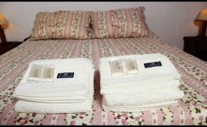 a bed with white towels on top of it at Litoral Apart in Eldorado +4 photos