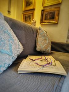 a book with a pair of glasses sitting on a couch at Lyssa Holiday Apartments in Taormina