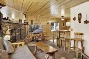 a living room with a couch and a stone fireplace at Reality Escape by Big Bear Vacations in Big Bear City