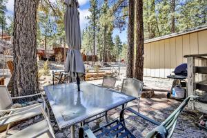 a glass table with chairs and an umbrella at Reality Escape by Big Bear Vacations in Big Bear City