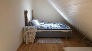 um pequeno quarto com uma cama no sótão em Sportsmen´s Holiday House em Otepää