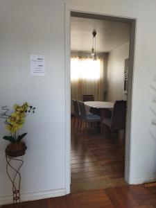 a hallway with a table and a dining room at Pousada Guaíra in Guaíra +17 photos