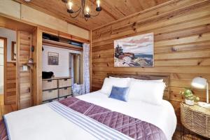 Un dormitorio con una cama en una habitación con paredes de madera. en The Nest on Towne Trail by Big Bear Vacations, en Big Bear Lake 41 fotos más