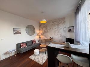 a living room with a couch and a table at Le Vercingetorix - Appartements meublés in Gien