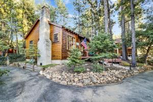 una cabaña de madera con una bandera americana delante de ella en The Nest on Towne Trail by Big Bear Vacations, en Big Bear Lake